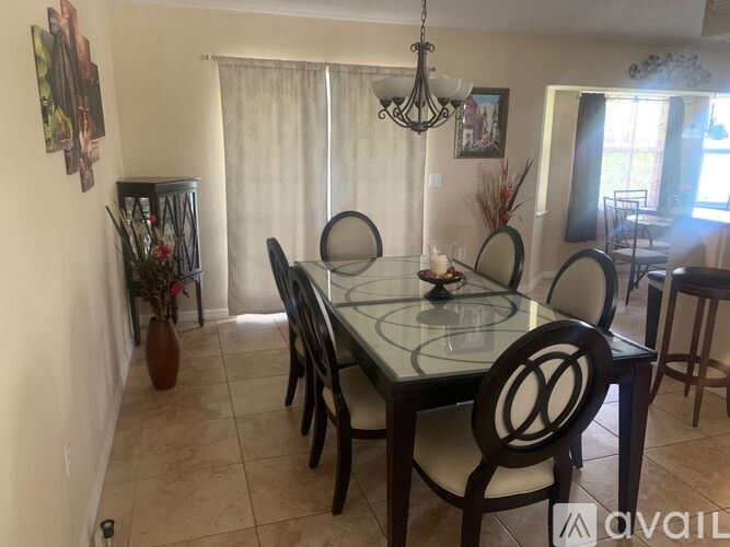 A dining room with a glass table and chairs.