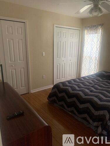 A bedroom with a bed, a dresser, and a window.