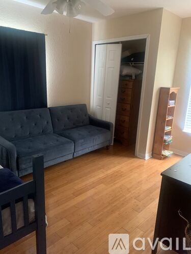 A living room with a grey couch and a wooden floor.