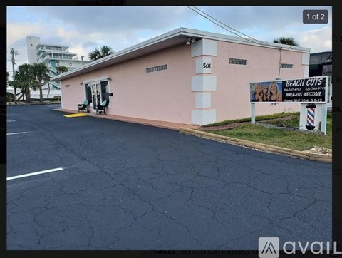 A pink building with a sign that says "BEACH CUTS" on it.