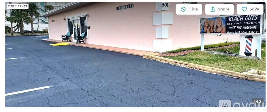 A pink building with a sign that says "BEACH CUTS" in front of it.