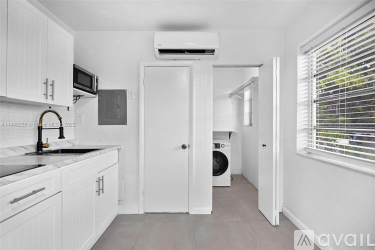A kitchen with white cabinets and a black countertop.