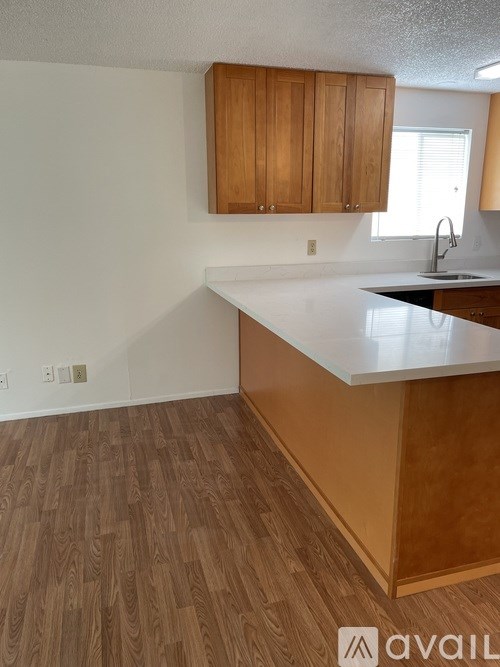 A kitchen with wooden cabinets and a white countertop.