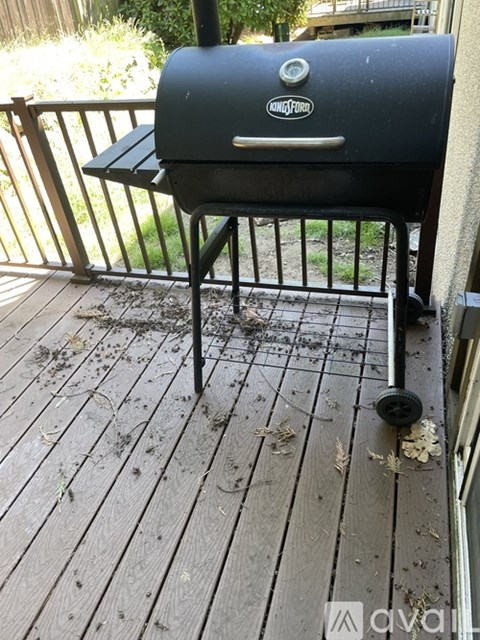 A black grill with the word "Smoke" on it is on a wooden deck.