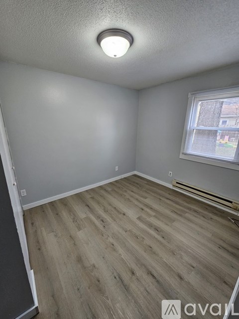 A room with wooden flooring and a window.