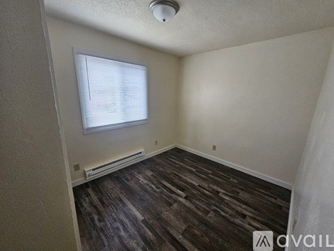 A room with wooden flooring and a white door.