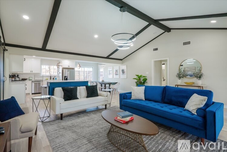 A living room with a blue couch and a white sofa.
