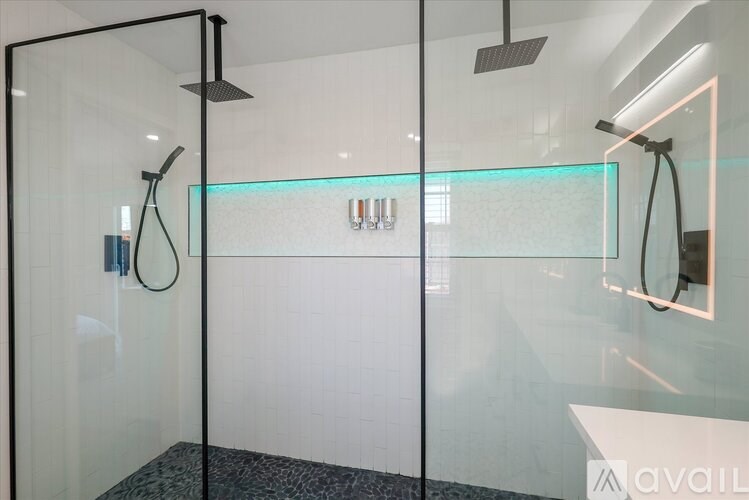 A modern bathroom with a glass shower enclosure and a glass-topped sink.