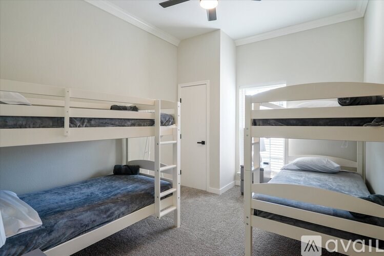 A room with two bunk beds and a ceiling fan.