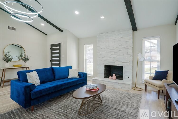 A living room with a blue couch and a fireplace.