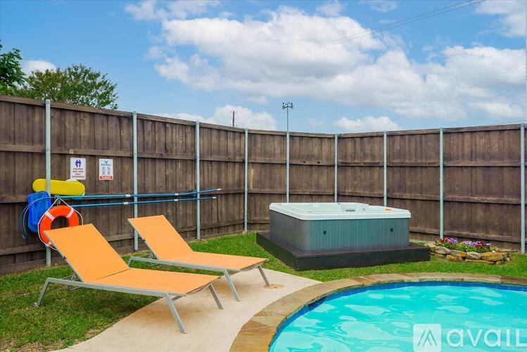 A pool with a slide and two sun loungers.
