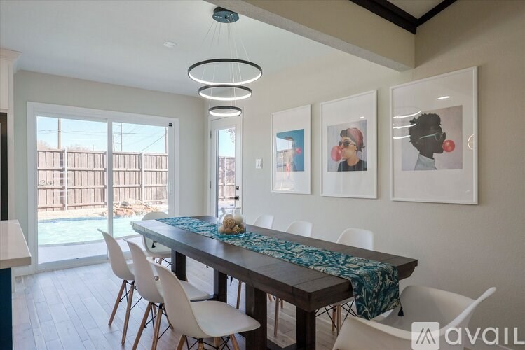 A dining room with a table and chairs and pictures on the wall.