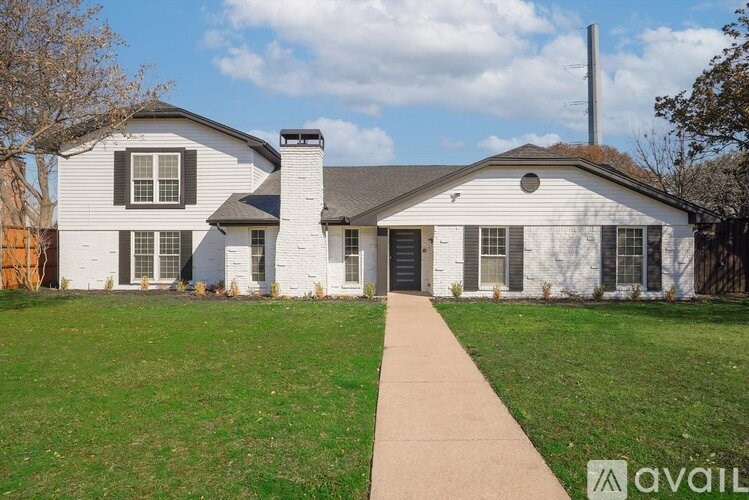 A white house with a brown walkway in front.