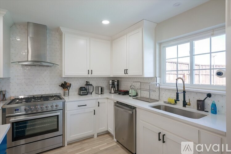 A kitchen with white cabinets and a stainless steel oven.