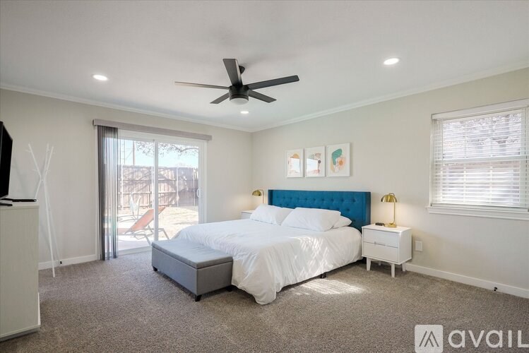 A bedroom with a bed, nightstand, and a ceiling fan.