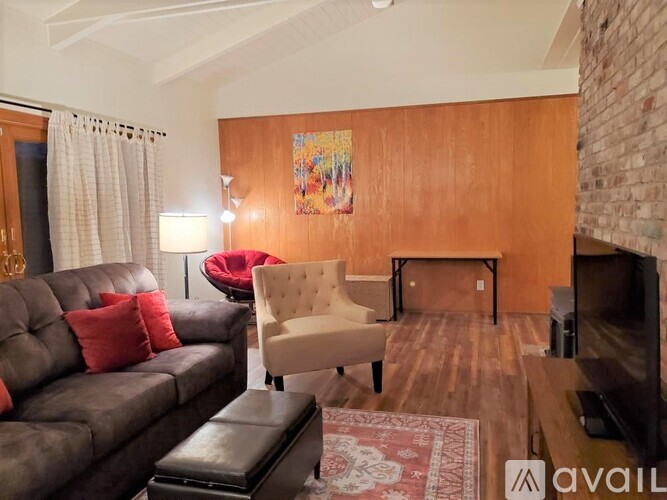 A living room with a brown couch, a chair, and a fireplace.