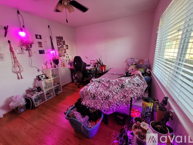 A room with a bed, a chair, and a table with various items on it.