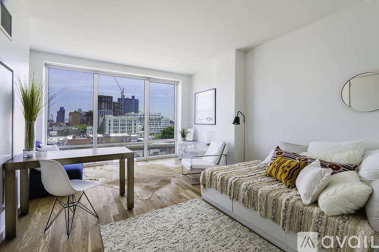 A bedroom with a large bed and a desk with a chair.