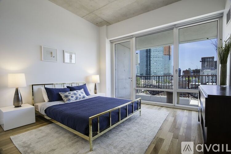 A bedroom with a large bed and a view of the city.