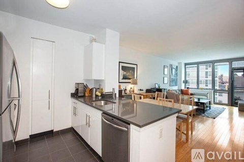 A kitchen with white cabinets and a black countertop.
