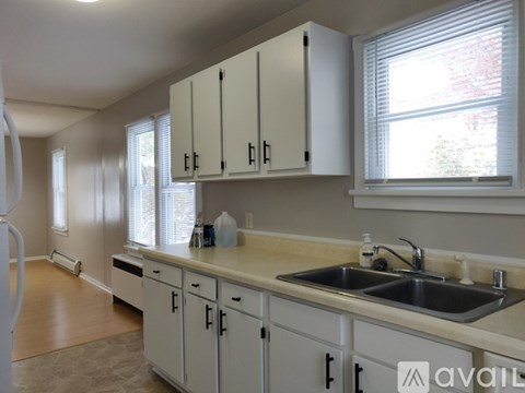 A kitchen with white cabinets and a sink.