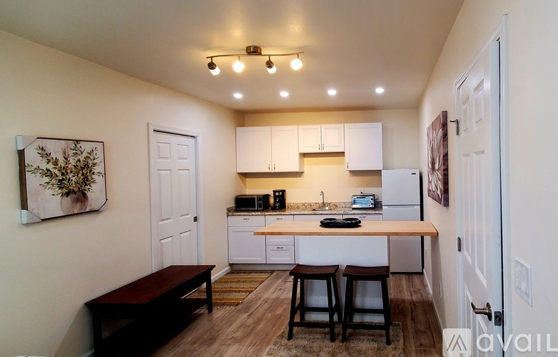 A kitchen with white cabinets and a wooden island.