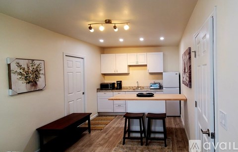 A kitchen with white cabinets and a wooden island.