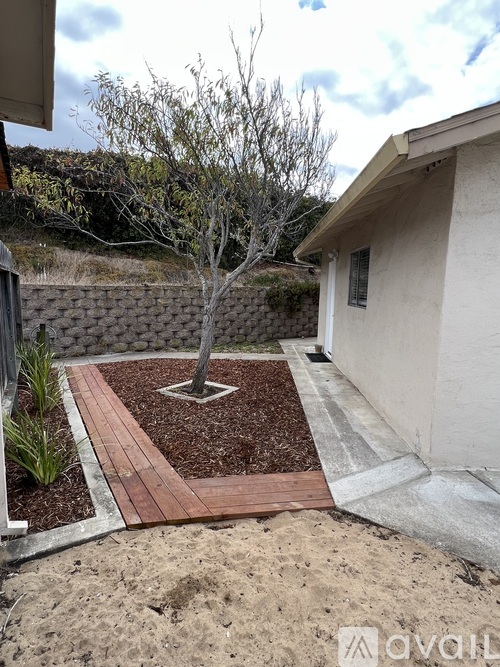 A small bathroom with a toilet, a walk in shower and a mat on the floor.