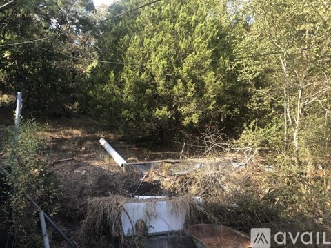 A construction site with a large pipe in the foreground and trees in the background.