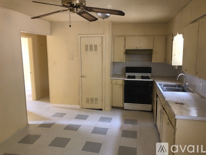 A kitchen with a fan and a checkered floor.