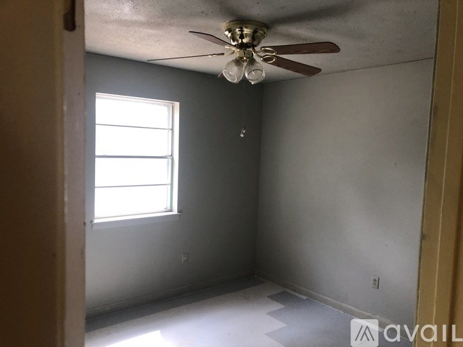 A room with a ceiling fan and a window.