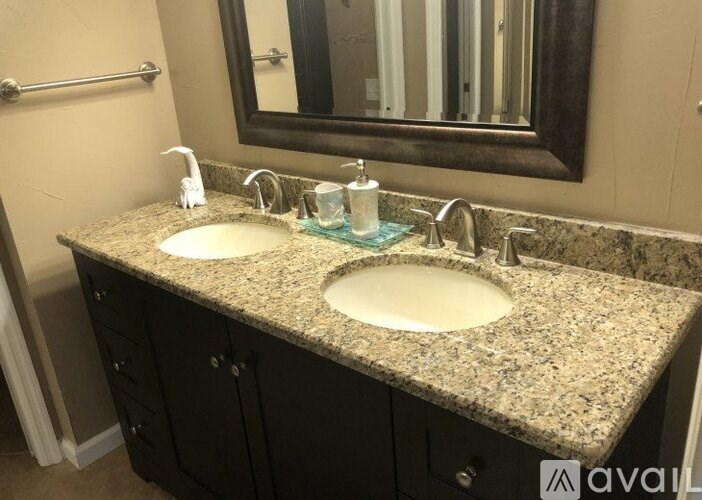 A bathroom with two sinks and a mirror above them.