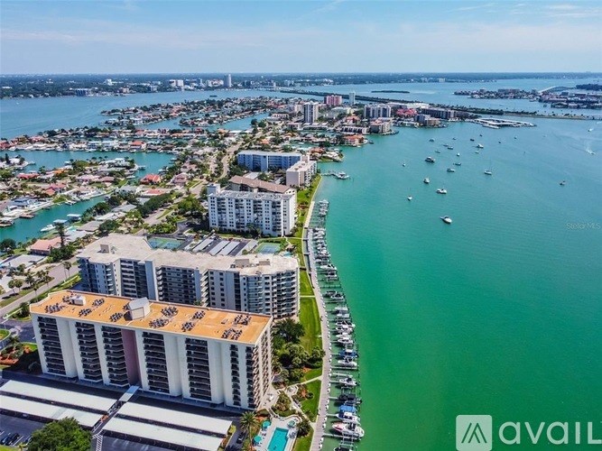 A large building with a sign that says "AVAIL" on it is situated by a body of water.