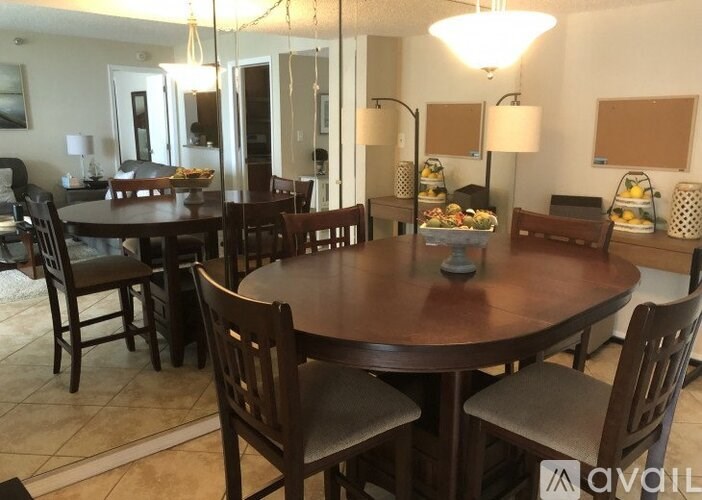 A dining room with a large table surrounded by chairs.
