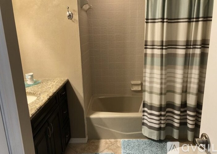 A bathroom with a shower curtain and a bathtub.