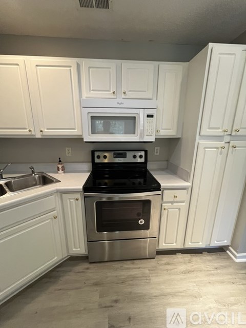 A kitchen with white cabinets and a stainless steel oven.