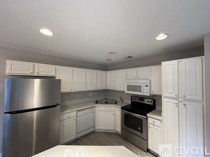 A kitchen with white cabinets and stainless steel appliances.