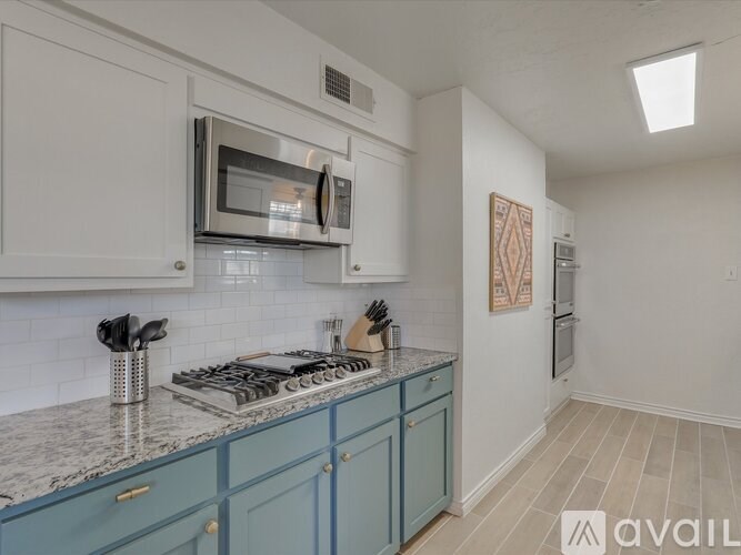 A kitchen with a blue counter and white cabinets.