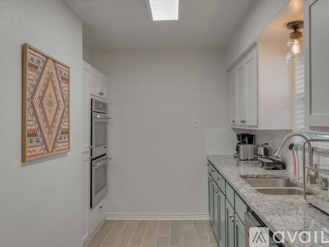 A kitchen with a sink, stove, and oven.