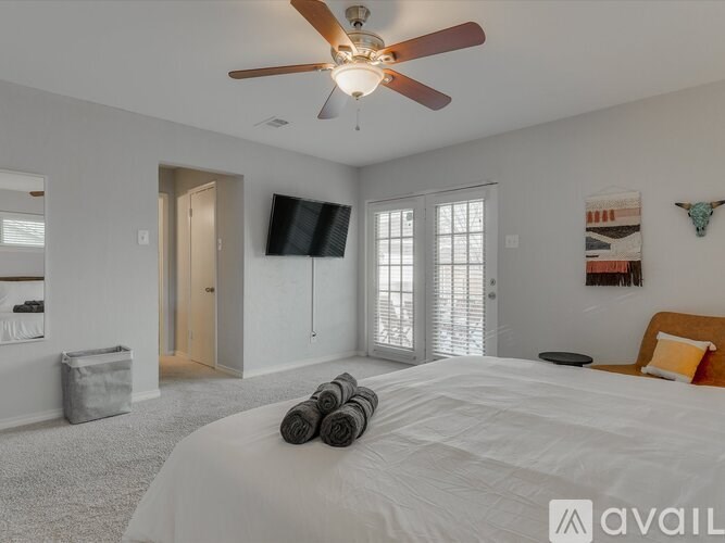 A bedroom with a large bed and a ceiling fan.