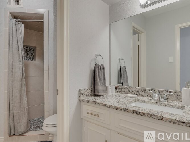A bathroom with a toilet, sink, and shower.