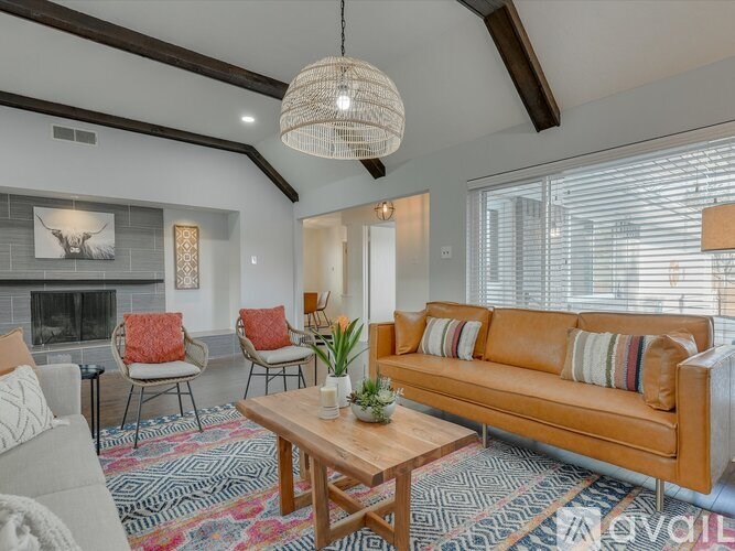 A living room with a brown couch, a fireplace, and a rug.