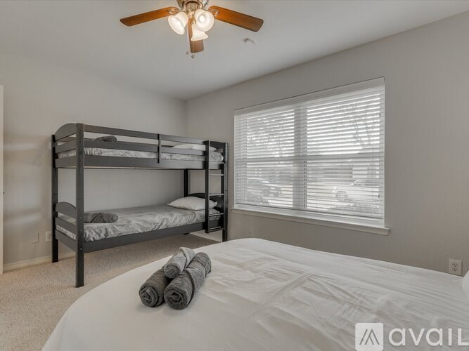 A bedroom with a bunk bed and a white bed.