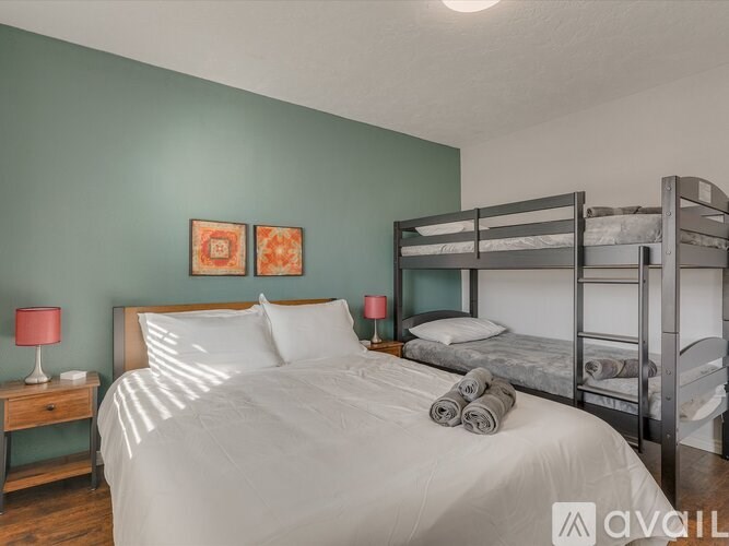 A bedroom with a white bed and a bunk bed.