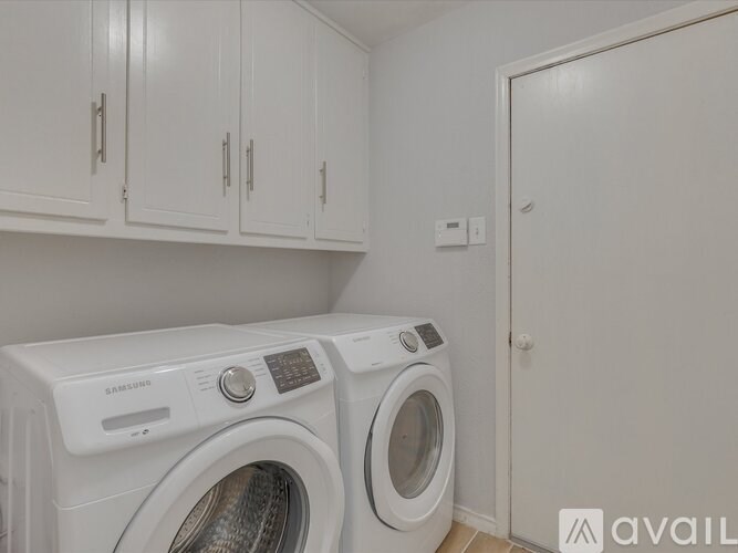 A white Samsung washing machine and dryer in a laundry room.
