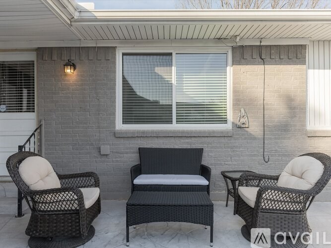 A patio with a sofa, two chairs and a table.