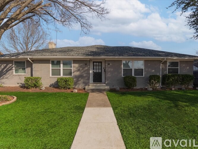 A house with a grey roof and a green lawn in front.