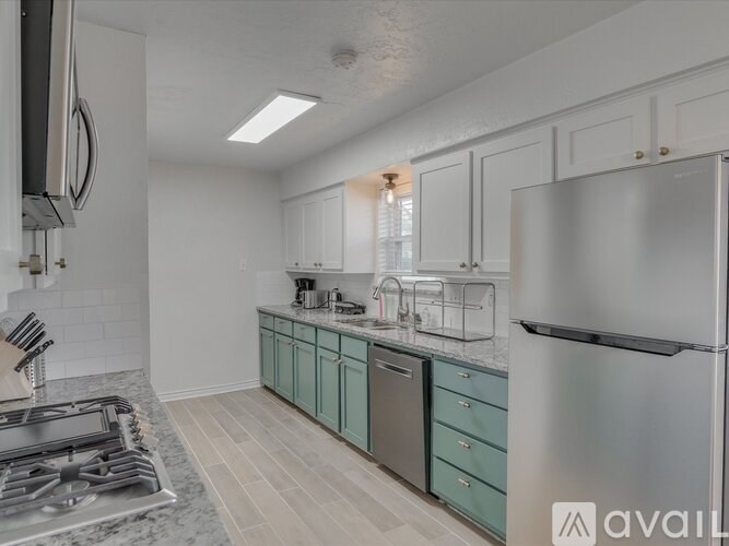 A kitchen with a stainless steel refrigerator and a stove top oven.