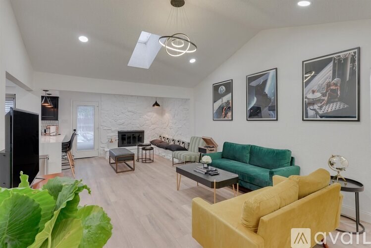 A living room with a yellow couch and a fireplace.