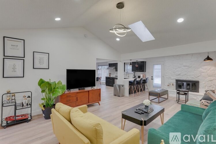 A living room with a yellow sofa and a black coffee table.